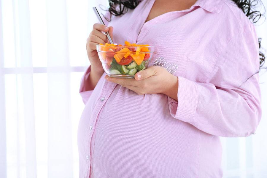 Pregnant woman eating healthy bowl of food