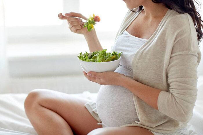 Pregnant woman eating healthy bowl of food