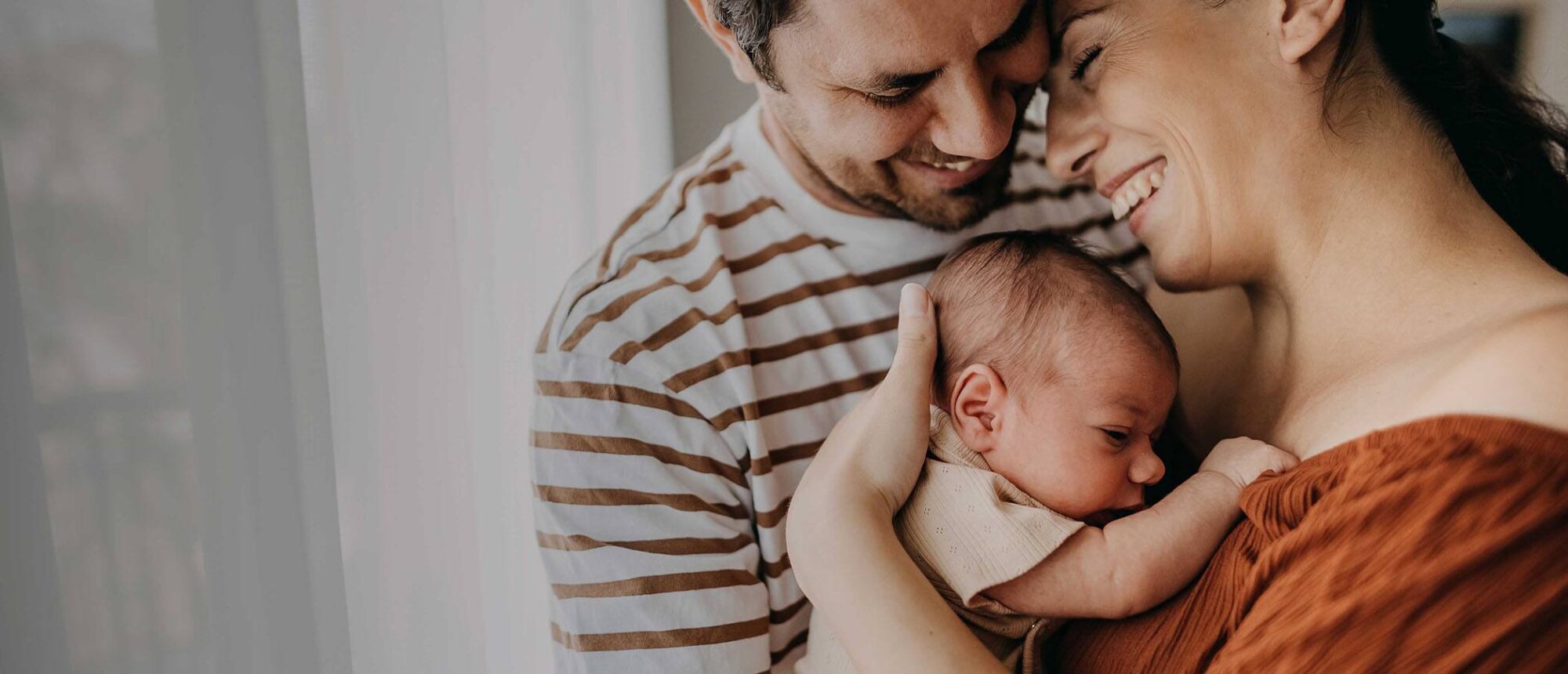 Happy parents hugging baby